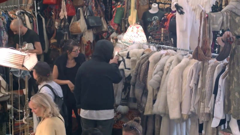 A Busy Scene Inside Artists & Fleas in Williamsburg, with Shoppers Browsing Through Racks of Clothing and Accessories