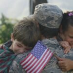 Soldier hugs his kids in front of the house