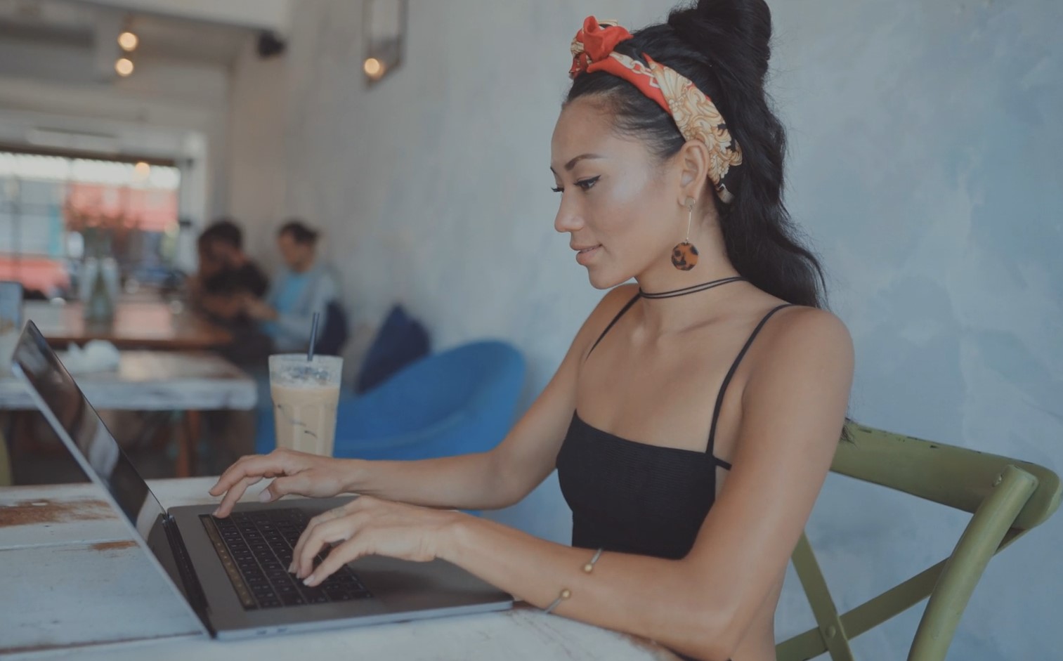 Woman writing blog on a laptop in a caffe