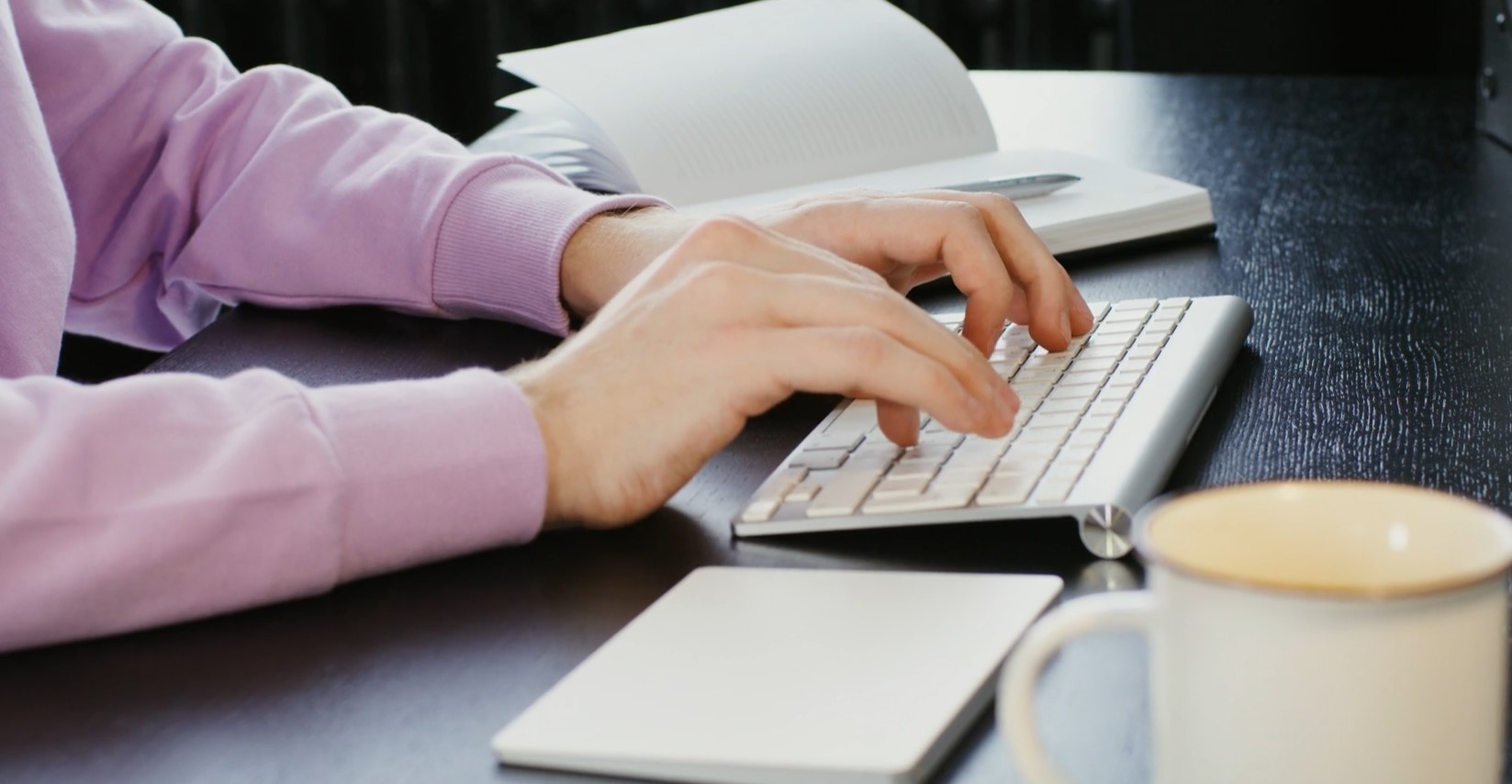 Woman typing on a white keyboard