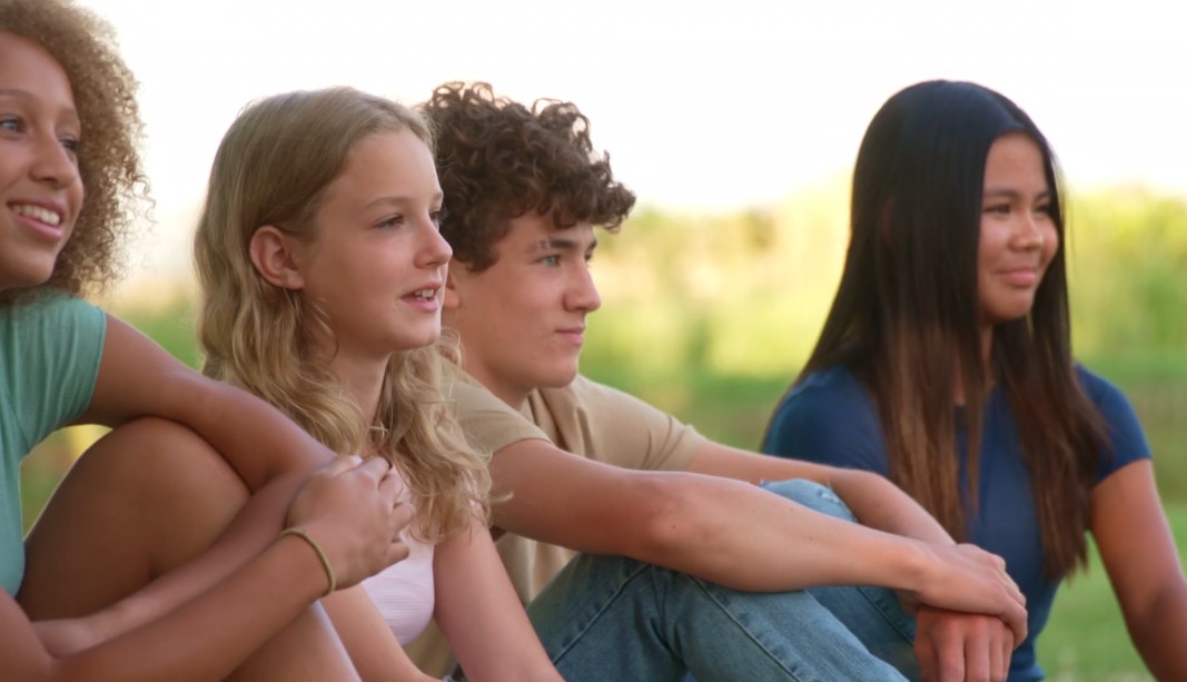 Teens sitting together on a grass