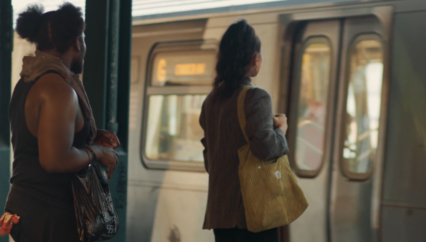 Two individuals wait patiently for the train