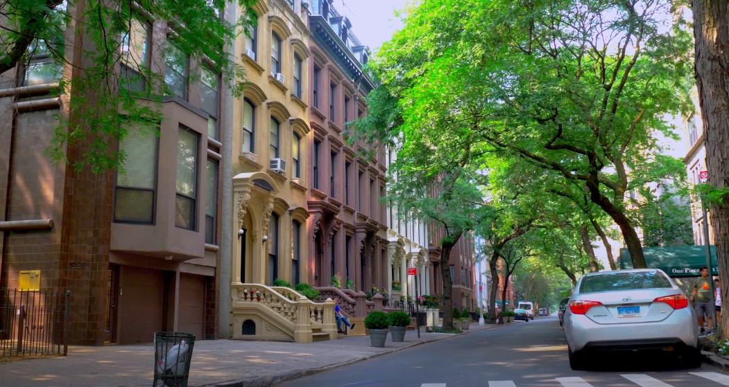 A quiet street lined with historic brownstones