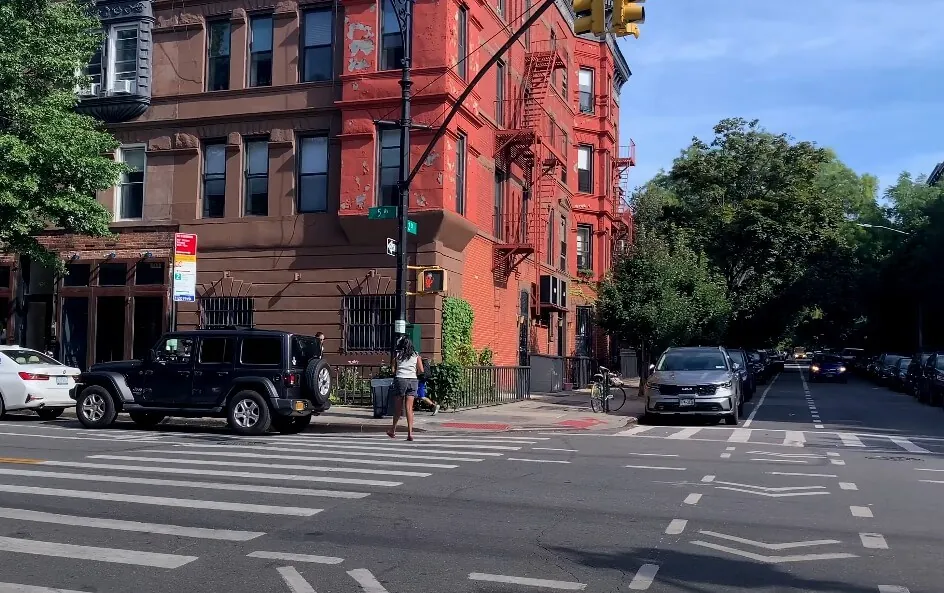 Colorful buildings line a city street, cars parked along the curb