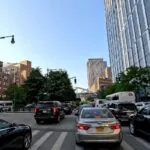 a view of a city street, showcasing the relentless flow of vehicles and the towering structures