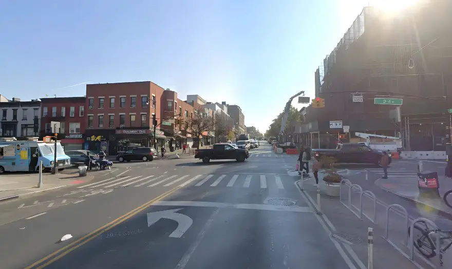 Pedestrians and vehicles share the space on a city street intersection