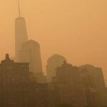 A hazy orange sky blankets the New York city skyline