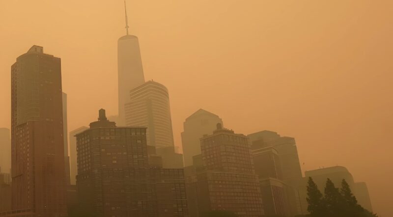 A hazy orange sky blankets the New York city skyline